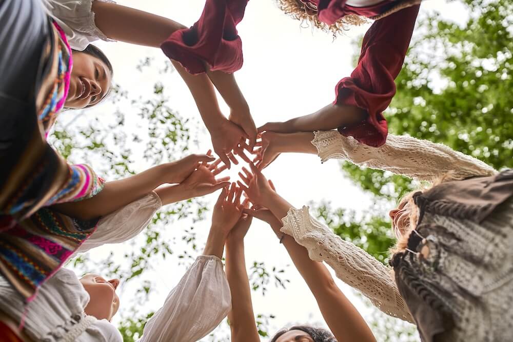Frauen bilden einen Kreis mit ihren Händen in der Mitte